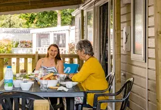 Famille sur la terrasse de son mobil home camping La Réserve
